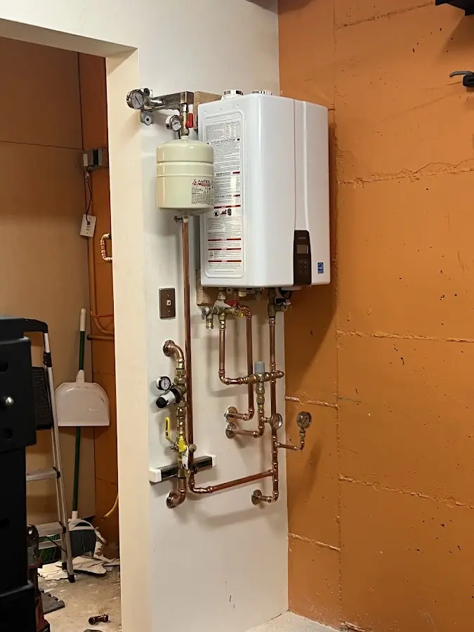 Plumbing technician inspecting water heater connections in Pantops